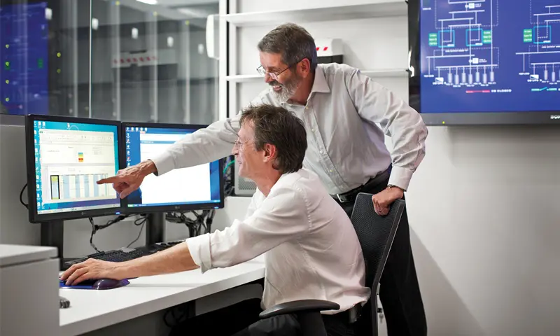 Two Engineers working at Data Centre Facility Sydney and looking at their computer screen.