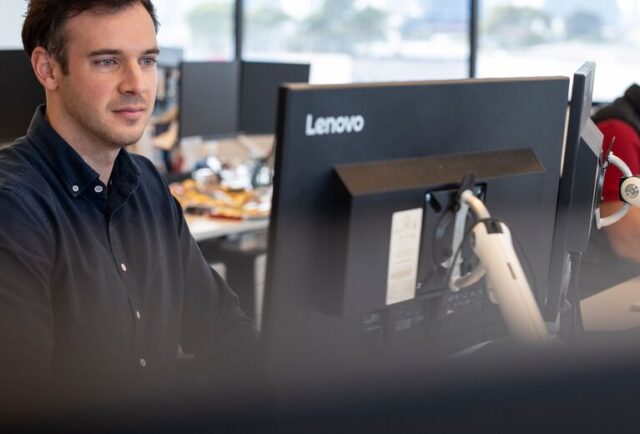 a person working at interactive pty looking at the computer doing work